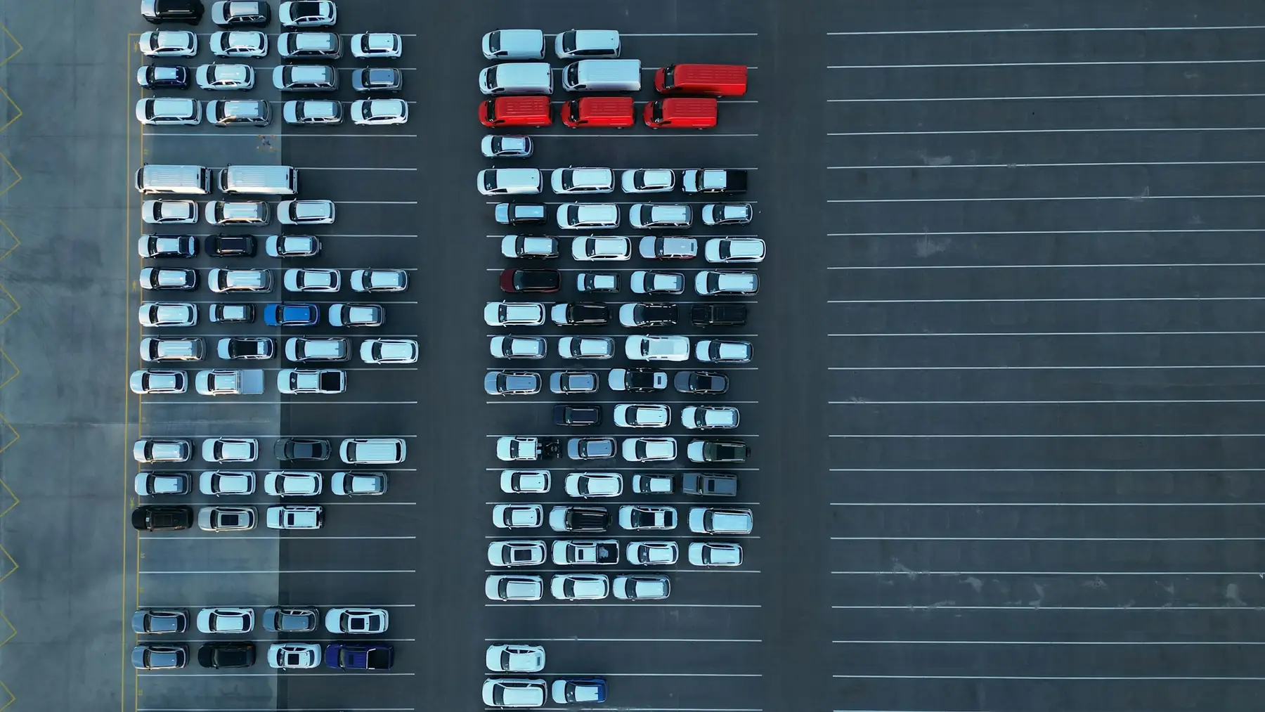 Aerial view of cars parked in neat rows in a large lot